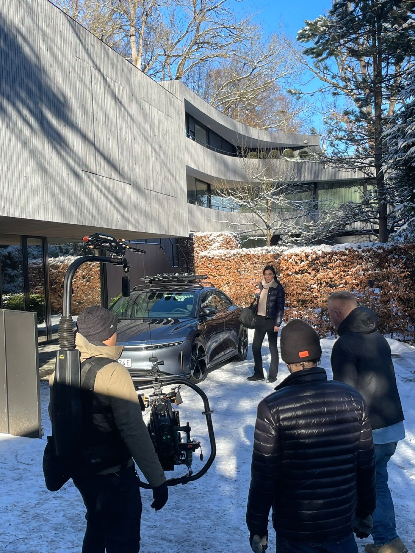 Steadicam operator filming the Lucid Air at a snowy villa